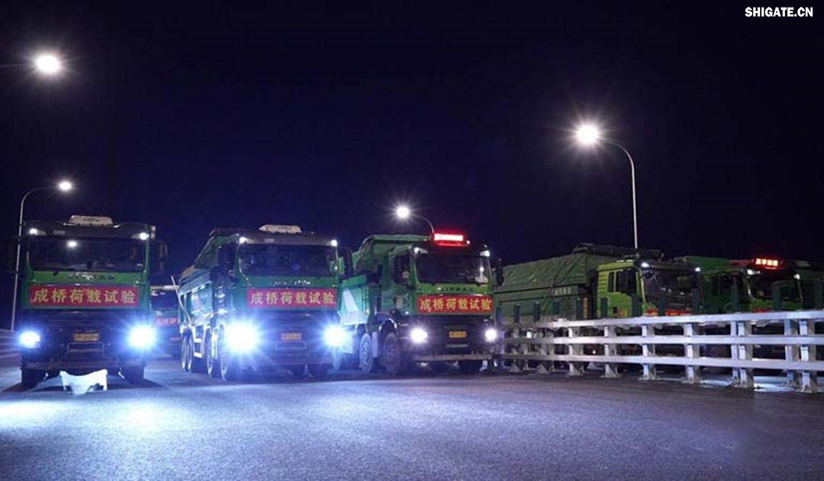 6月16日22時(shí)，世界最大跨度斜拉橋——常泰長(zhǎng)江大橋燈火通明，車聲轟鳴，一場(chǎng)通車前的“極限挑戰(zhàn)”正緊張進(jìn)行。30輛總重達(dá)1200噸的四軸加載車，分批列隊(duì)駛上橋面預(yù)先劃定的停靠點(diǎn)，并由提前布置在橋梁各關(guān)鍵部位的869個(gè)傳感器開展實(shí)時(shí)監(jiān)測(cè)，采集測(cè)試數(shù)據(jù)。由此，大橋跨江公鐵合建段主橋橋梁荷載試驗(yàn)全面啟動(dòng)。    AA1GQ79M.jpg    這次荷載試驗(yàn)覆蓋范圍具體包括1座主跨1208米斜拉橋、2座主跨388米鋼桁拱專用航道橋、1座非通航道孔橋以及南北兩座引橋，共設(shè)計(jì)119個(gè)靜載工況和111個(gè)動(dòng)載工況。其中，最大對(duì)稱靜力加載工況將動(dòng)用110輛四軸加載車，總重達(dá)4400噸。試驗(yàn)將持續(xù)一周，分五個(gè)階段進(jìn)行。試驗(yàn)首日在錄安洲非通航孔橋和常州側(cè)公鐵合建段引橋?qū)嵤? 常泰長(zhǎng)江大橋是連通常州與泰興的跨江通道，是長(zhǎng)江上首座集高速公路、城際鐵路和普通公路三種功能于一體的雙層復(fù)合型橋梁，計(jì)劃于今年年內(nèi)基本建成。它的上層為雙向六車道高速公路，下層為雙線城際鐵路和普通公路。如此復(fù)雜的結(jié)構(gòu)，如何確保它在未來(lái)百年服役中安全可靠？答案就藏在荷載試驗(yàn)中。    AA1GQduQ.jpg    荷載試驗(yàn)堪稱橋梁通車前的“綜合大考”，是確保橋梁安全運(yùn)營(yíng)的“體檢報(bào)告”。江蘇省交通工程建設(shè)局常泰長(zhǎng)江大橋建設(shè)指揮部現(xiàn)場(chǎng)常務(wù)副指揮長(zhǎng)夏鵬飛介紹，“荷載試驗(yàn)是檢測(cè)橋梁結(jié)構(gòu)安全和承載能力的重要手段，通過科學(xué)的加載測(cè)試和數(shù)據(jù)采集分析，驗(yàn)證實(shí)際成橋狀態(tài)與理論設(shè)計(jì)的鍥合度，確保常泰長(zhǎng)江大橋運(yùn)營(yíng)安全。”考慮到大橋主體采用鋼結(jié)構(gòu)和鋼-混凝土組合結(jié)構(gòu)，為最大限度減少晝夜溫差對(duì)測(cè)試數(shù)據(jù)的影響，所有試驗(yàn)均安排在夜間實(shí)施。  通過一系列科學(xué)嚴(yán)謹(jǐn)?shù)暮奢d測(cè)試，這座世界級(jí)多功能大橋的實(shí)際性能將得到充分檢驗(yàn)，為常泰長(zhǎng)江大橋后續(xù)安全通車運(yùn)營(yíng)提供至關(guān)重要的數(shù)據(jù)支撐。